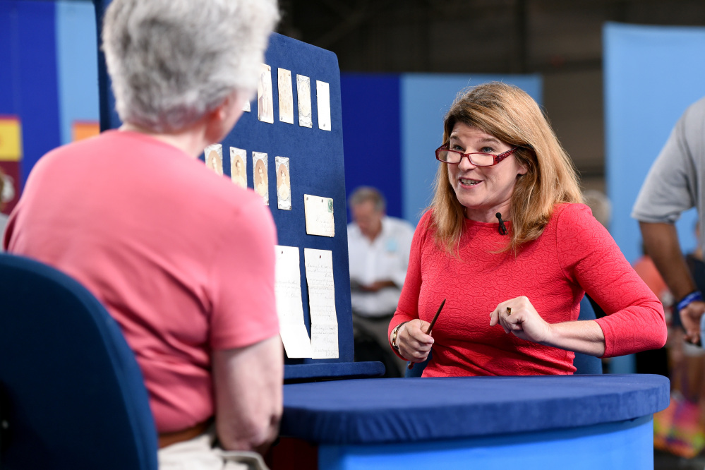This Aug. 9, 2014 photo released by Antiques Roadshow shows Leila Dunbar appraising a collection of early Boston baseball memorabilia for the program “Antiques Roadshow” in New York.