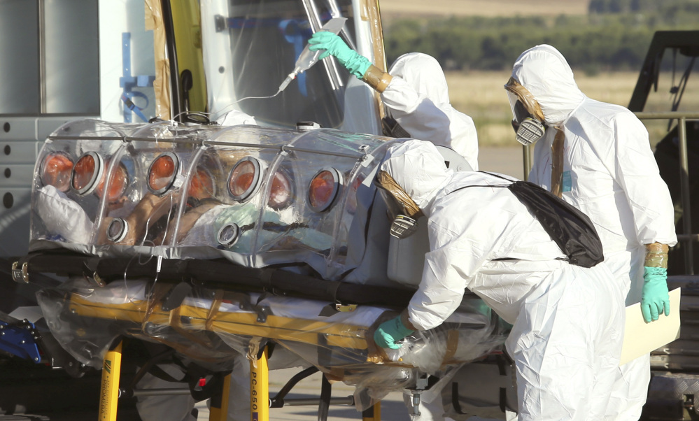 In this Aug. 7, 2014 file photo provided by the Spanish Defense Ministry, aid workers and doctors transfer Miguel Pajares, a Spanish priest who was infected with the Ebola virus while working in Liberia, from a plane to an ambulance as he leaves the Torrejon de Ardoz military airbase, near Madrid, Spain.