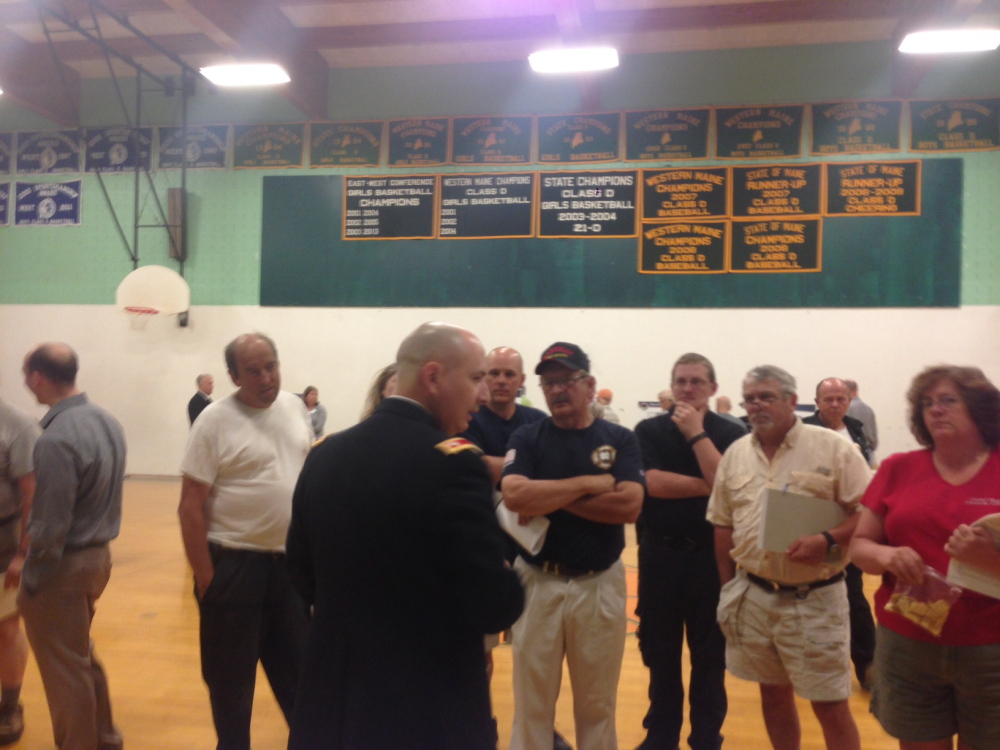 Plain Text:Army Lt. Col. Dan Martin speaks to a group including Rangeley Selectman Rob Welch, second from right, on Tuesday night at an information-gathering session in Rangeley about a proposal to build a missile interceptor facility at nearby Redington Township.