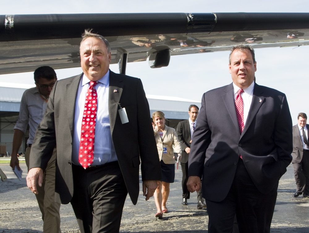 Maine Gov. Paul LePage and New Jersey Gov. Chris Christie walk beneath an aircraft wing during a tour of C & L Aerospace in Bangor on Tuesday.