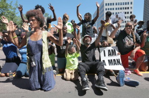 Protesters drop to their knees and put their arms in the air during a rally for Michael Brown Jr., who was shot and killed by a Ferguson, Mo., police officer on Aug. 9.