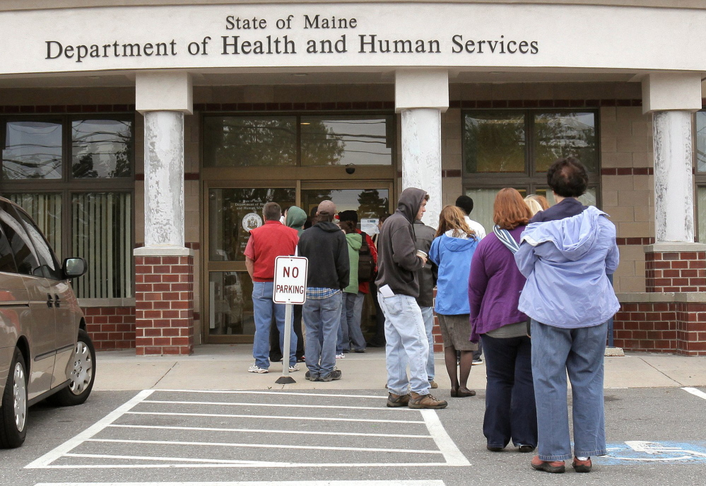 Gregory Rec/Staff Photographer: 
 People wait outside the entrance to the Department of Health and Human Services building in Portland on Monday, October 4, 2010.