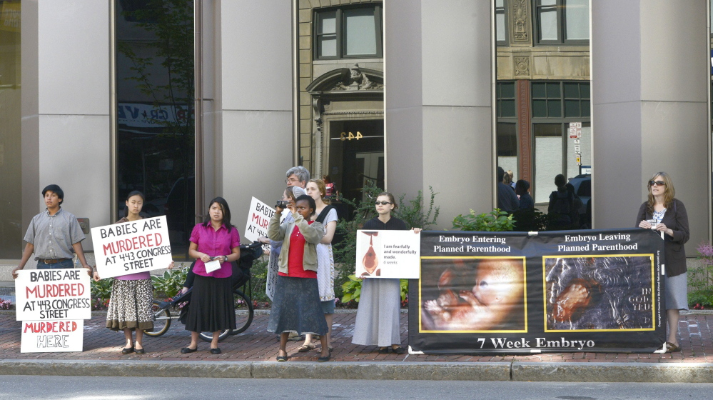 Anti-abortion protesters stand across the street from the Planned Parenthood clinic at 443 Congress St. on July 11. Portland’s 39-foot no-protest buffer zone was lifted July 7.