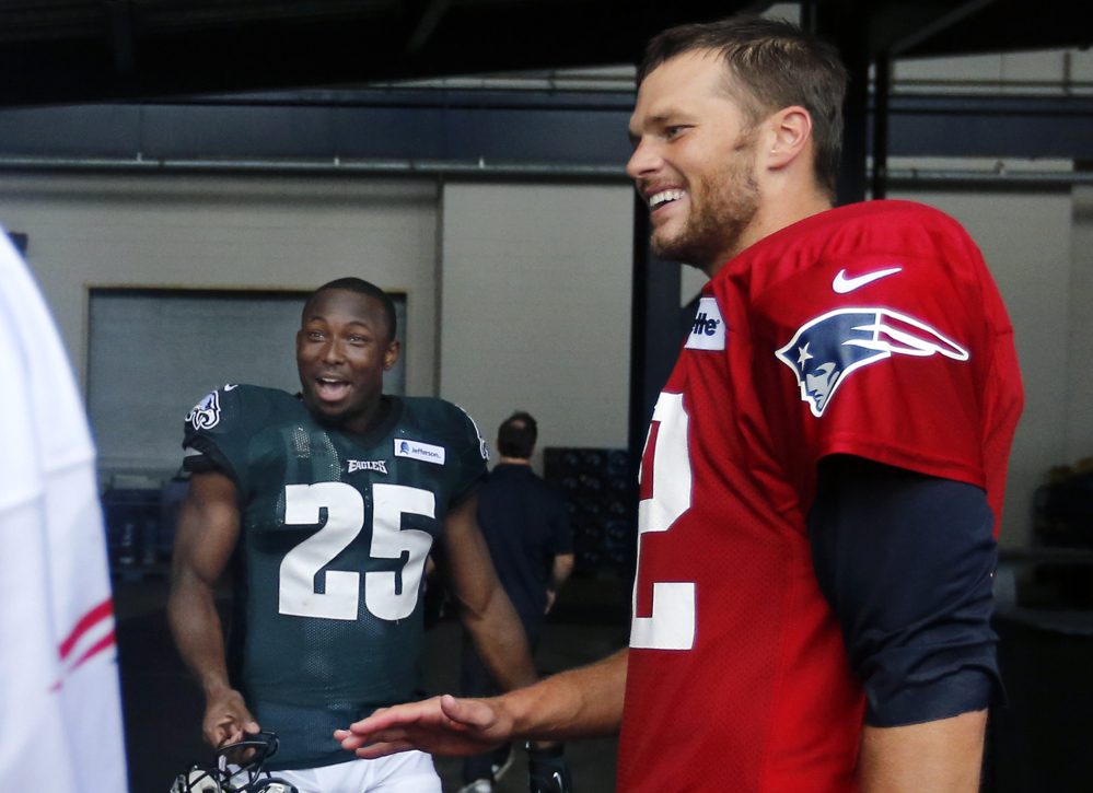 New England Patriots quarterback Tom Brady, right, and Philadelphia Eagles running back LeSean McCoy (25) chat after a joint NFL training camp practice Wednesday in Foxborough, Mass.