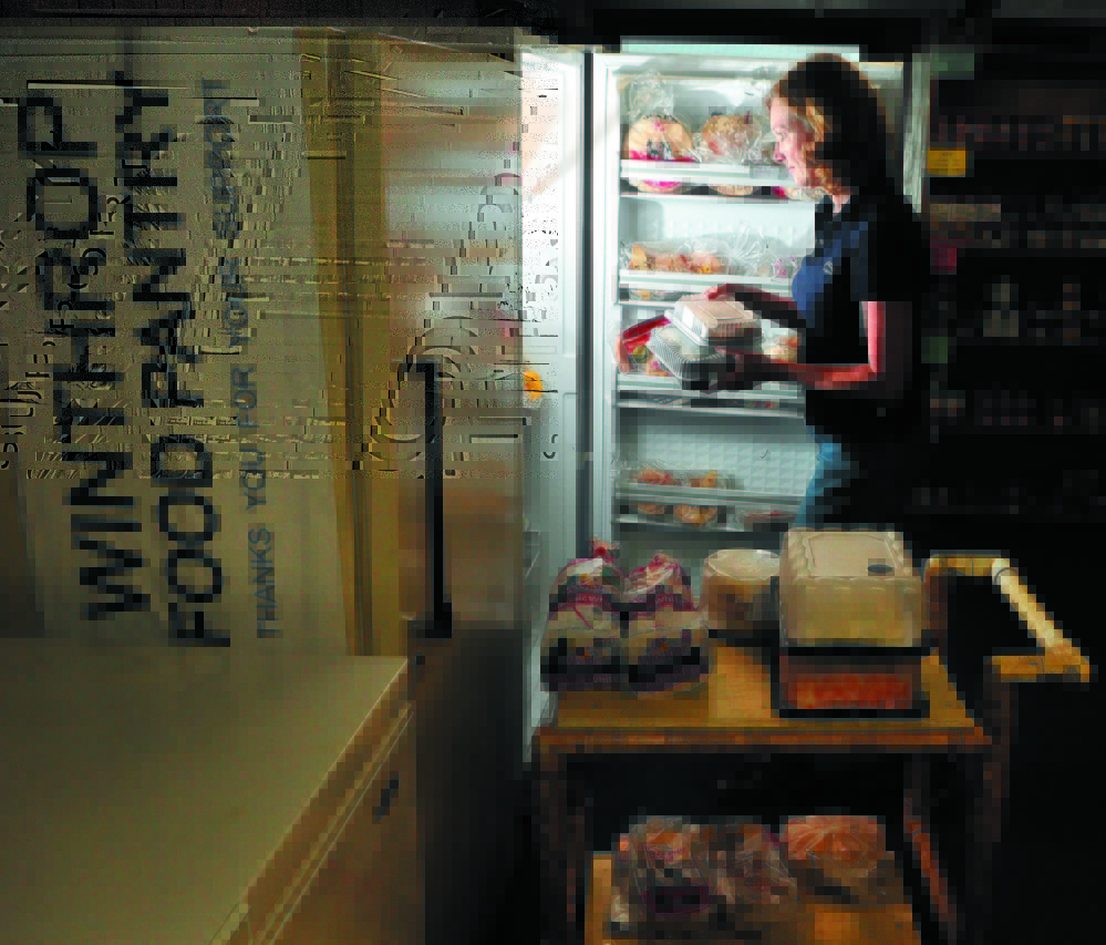 JoEllen Cottrell takes baked goods from the freezer as she and other volunteers set up the Winthrop Food Pantry in June 2011. A fundraiser Saturday will help raise money for growing need at the pantry.