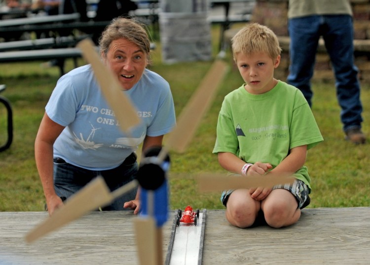 Tanner Mayo, 9, of Temple, learns about wind power on Friday, Aug. 15, 2014, from Lisa Twombly, Maine Wind Blade Challenge coordinator, an event sponsored by Wind for Maine and the Maine Ocean and Wind Industry Initiative at the Skowhegan State Fair.