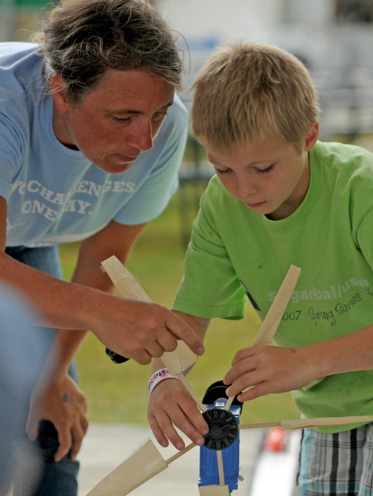 Tanner Mayo, 9, of Temple, builds a wind mill to power a toy car with the help of Lisa Twombly, Maine Wind Blade Challenge coordinator. The event was sponsored by Wind for Maine and the Maine Ocean and Wind Industry Initiative at the Skowhegan State Fair on Friday.