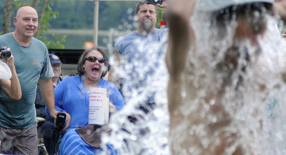 Carole and Steve Marson, left, watch people dump ice Sunday over their heads during an ALS ice bucket challenge in South Gardiner. Carole Marson has ALS.