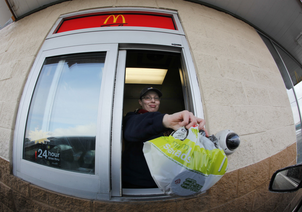 In this Jan. 26, 2009 file photo, McDonald’s employee Cortney Sobowiec hands a patron a salad at the drive up window at McDonalds in Williamsville, N.Y.