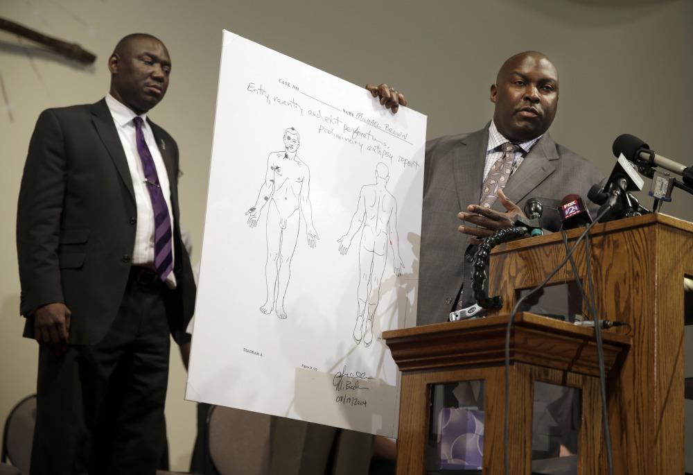 Attorneys Daryl Parks, right, and Benjamin Crump share preliminary results of a second autopsy done on Michael Brown, Monday in St. Louis County, Mo.