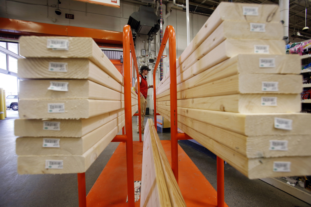 In this May 17, 2014 photo, a shopper checks out with her lumber at a Home Depot in Boston.