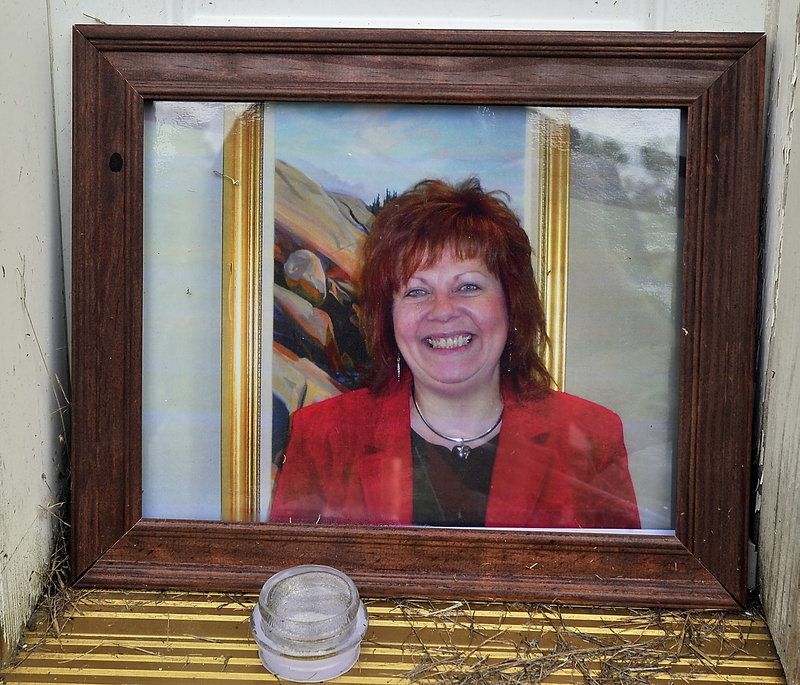 A memorial shows a photo of Lynn Arsenault, 55, who was killed in Belfast in 2013.