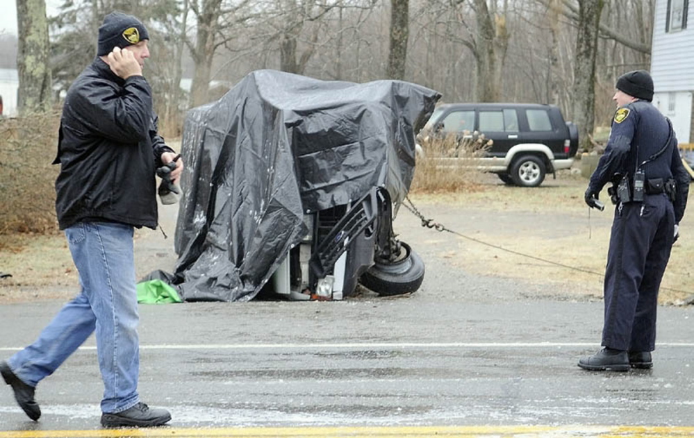 Gardiner Police Chief James Toman, left, and Officer Dan Murray investigate a rollover accident Dec. 31, 2011, that claimed the lives of two men and injured a third on U.S. Route 201 in Gardiner. The accident occurred after 8 a.m. in icy conditions.