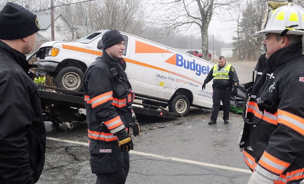 Gardiner police and firefighters remove a van that rolled over Dec. 31, 2011, and claimed the lives of two men and injured a third on U.S. Route 201 in Gardiner. The accident occurred after 8 a.m. in icy conditions.