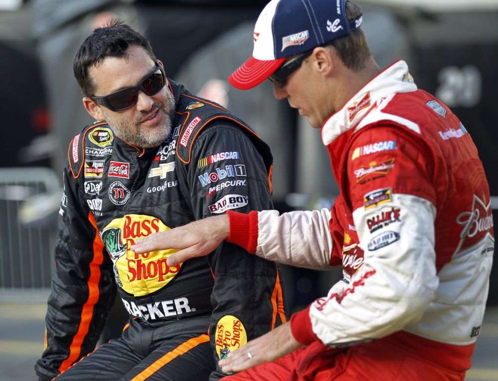 In this May 2014 photo, Tony Stewart, left, talks with Kevin Harvick before qualifying for a NASCAR Sprint Cup series auto race at Charlotte Motor Speedway in Concord, N.C. Stewart is skipping a third straight Sprint Cup race, and it is not clear when the NASCAR star might return after he struck and killed a driver at a dirt-track race in New York weeks ago.