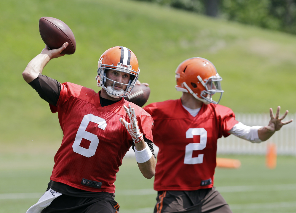 Cleveland Browns quarterback Brian Hoyer (6) passes with Johnny Manziel (2) during practice at the team’s facility in Berea, Ohio on Wednesday. Hoyer was named the opening day starter.