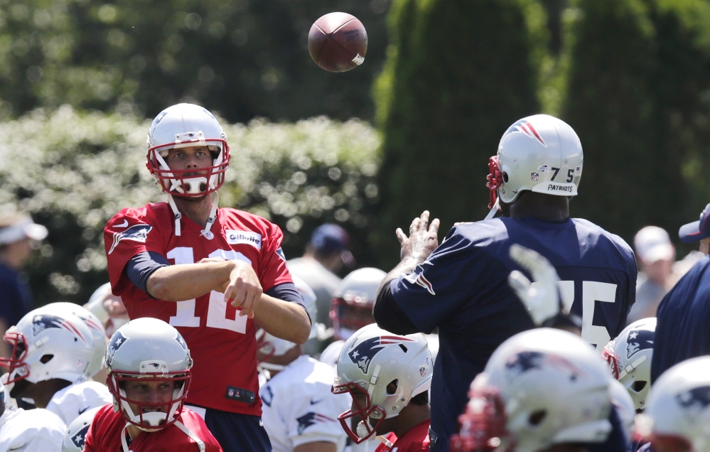 New England Patriots quarterback Tom Brady throws a pass to defensive tackle Vince Wilfork (75) during practice Wednesday in Foxborough, Mass.