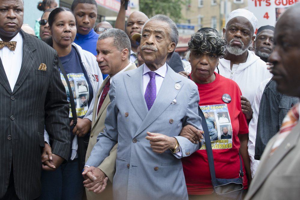 The Rev. Al Sharpton, center, holds hands with former New York Gov. David Paterson, center left, and Gwen Carr, mother of Eric Garner, alongside Esaw Garner, second from left, as they arrive before a march to protest the death of 43-year-old Eric Garner on Saturday.