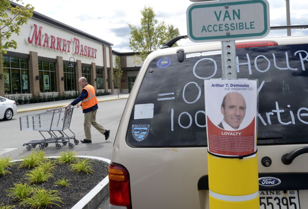 Employees at the Market Basket in Biddeford try to stay busy on Saturday while the company’s board of directors meet to consider the latest offer from Arthur T. Demoulas