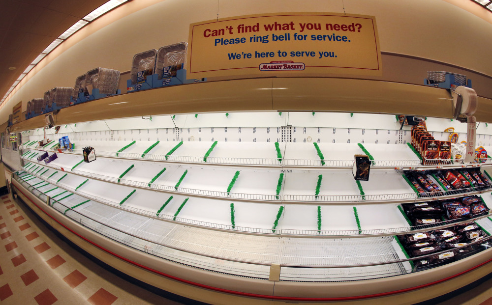 A sign sits atop mostly empty meat shelves at Market Basket in Haverhill, Mass.
