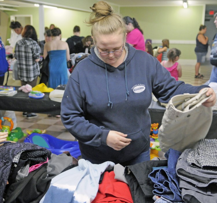 Kelly Smith, of Augusta, browses among the offerings Saturday during a clothing giveaway at Kennebec Community Church in Augusta.