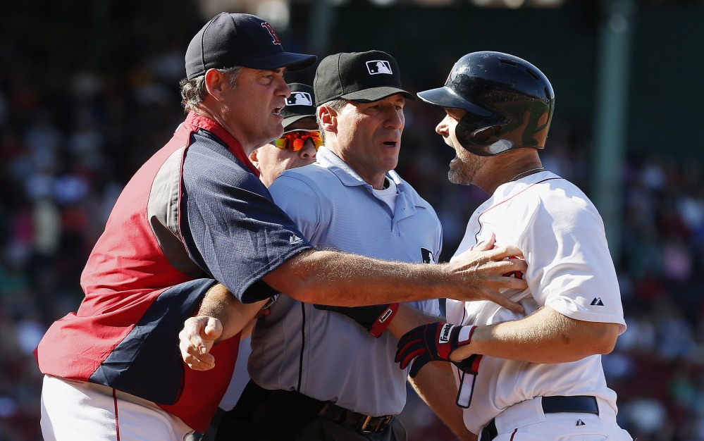 Boston Red Sox manager John Farrell, left, and home plate umpire Angel Hernandez, center, restrain David Ross after he was ejected by first base umpire Vic Carapazza during the eighth inning against the Seattle Mariners on Saturday in Boston. The Mariners won 7-3.