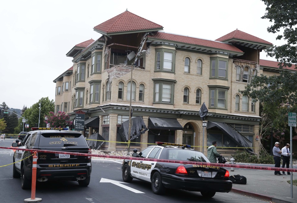 Police cars block the street outside a heavily damaged building following an earthquake on Sunday in Napa, Calif.