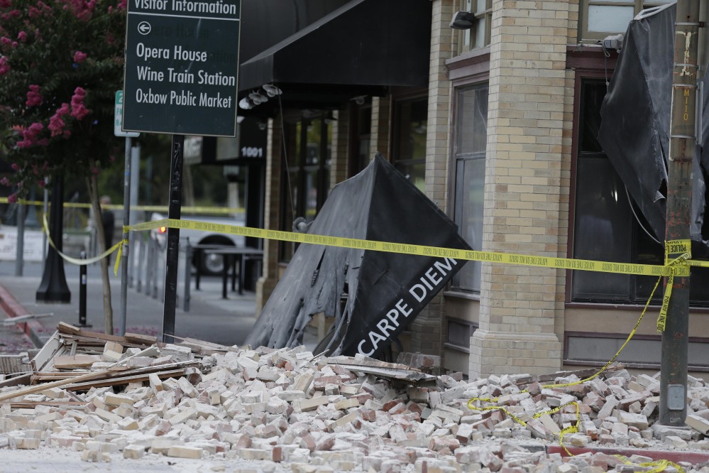 Bricks and rubble cover the sidewalk in front of a heavily damaged building following an earthquake on Sunday in Napa, Calif.