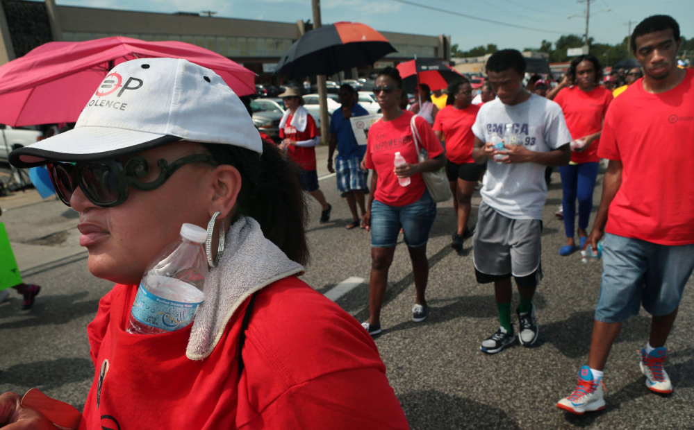 A member of the National Urban League, Dadre, kept cool as she marched during a peaceful march by members of the NAACP and the Urban League on West Florissant Avenue in Ferguson, Mo., on Saturday.