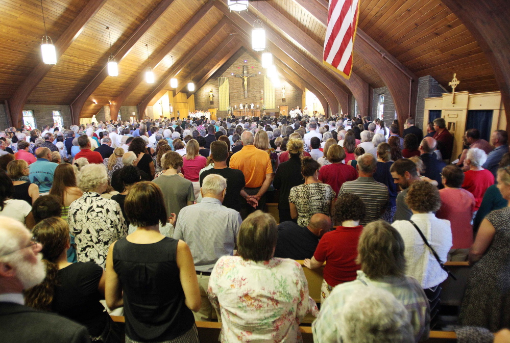 Mourners pack Our Lady of the Holy Rosary Catholic church during a special Mass for slain journalist James Foley in his hometown of Rochester, N.H., on Sunday. Bishop Peter Libasci implored those gathered not to hate but to heal.