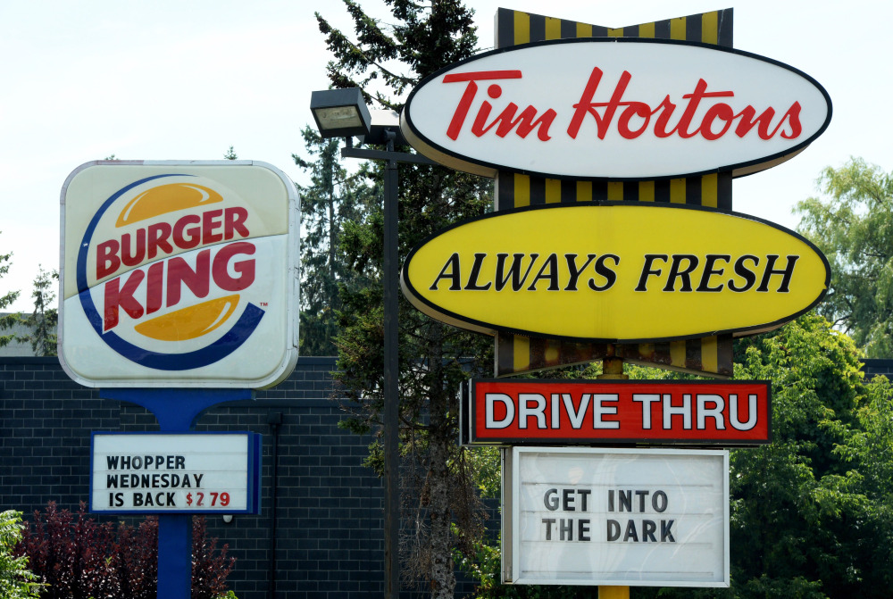 A Burger King sign and a Tim Hortons sign are displayed on St. Laurent Boulevard in Ottawa, Canada, on Monday.