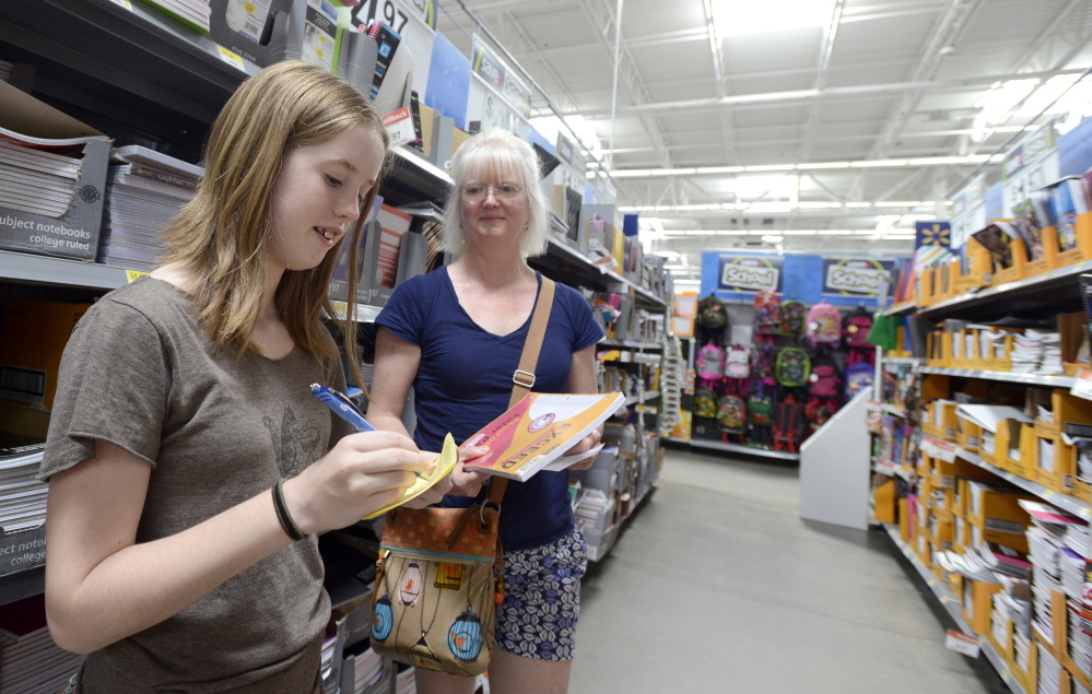 Twelve-year-old Lydia Valentine and her mother, Beth Valentine, from Gorham, check off items as they shop for school supplies Aug. 20 at Walmart in Scarborough.