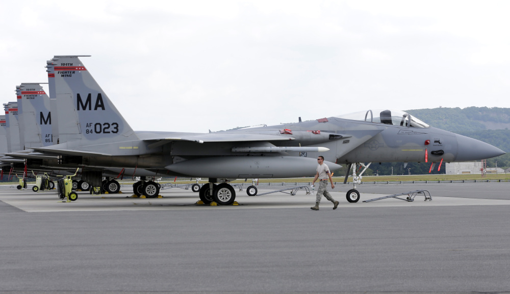 A Massachusetts Air National Guard aircraft maintenance worker walks past a row of F-15C fighter aircraft at Barnes Air National Guard Base in Westfield, Mass., on Wednesday.