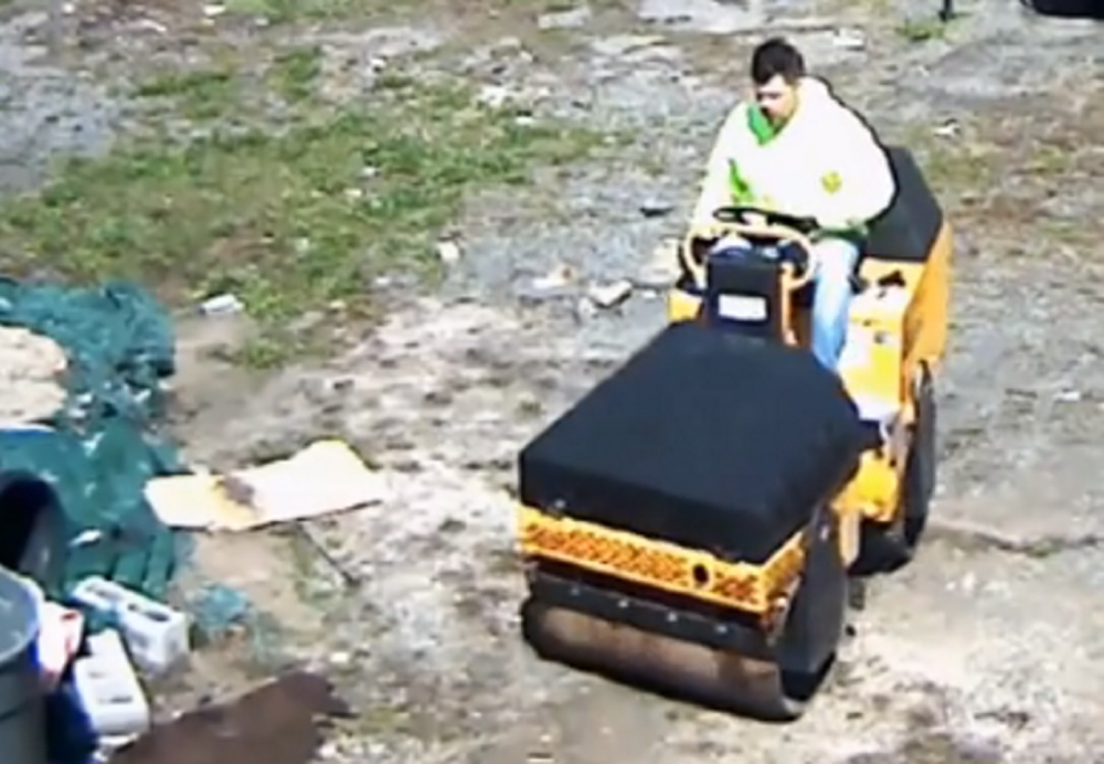 This screen image from video shows a suspect driving a paving roller away from a business in the Bronx