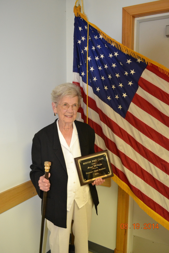 Hazel McCaslin holds Pittston’s Boston Post Cane and a commemorative plaque she received.