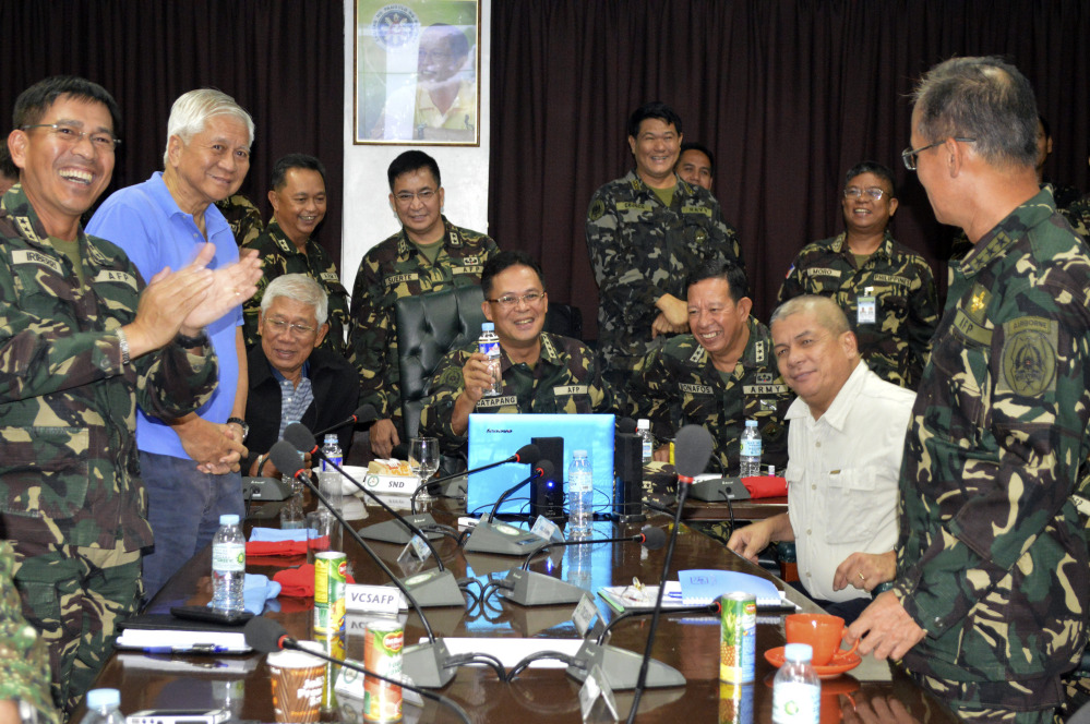 In this photo released by the Armed Forces of the Philippines Public Affairs Office, Philippine Military Chief Gen. Gregorio Catapang, center, reacts after learning about the safe repositioning of Filipino peacekeepers in Golan Heights as they monitor the situation with Philippine Foreign Affairs Secretary Albert Del Rosario, second left, Philippine National Defense Secretary Voltaire Gazmin, third from left seated, at Camp Aguinaldo military headquarters in suburban Quezon city, Philippines on Saturday.