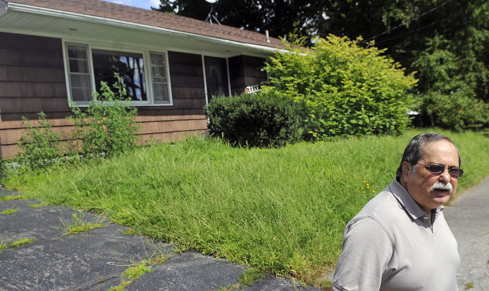Keith Ludden stands on Thursday in front of a house on Brooklawn Avenue in Augusta that was lost to foreclosure. Ludden, who lives on the same street, said the house has been abandoned since November, and failure to maintain it might degrade the value of neighboring homes.