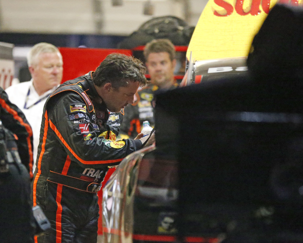 Tony Stewart looks over the damage to his car after he hit the wall during a NASCAR Sprint Cup race Sunday night at Atlanta Motor Speedway Sunday in Hampton, Ga. It was Stewart’s first race back after his sprint car struck and killed Kevin Ward Jr. at a New York dirt track on Aug. 9.