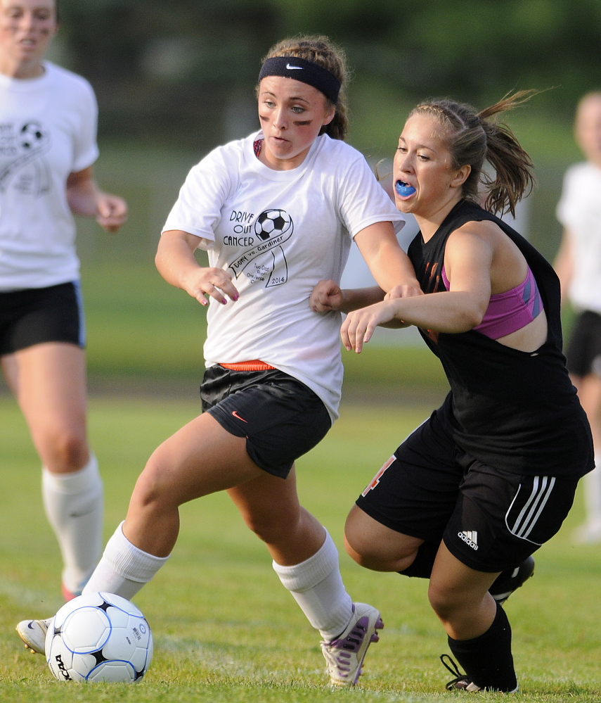 Cony High School’s Katelyn Bilodeau, left, and Gardiner Area High School’s Jordan Granholm scramble for the ball Tuesday during the Drive Out Cancer Challenge at Hoch Field in Gardiner.