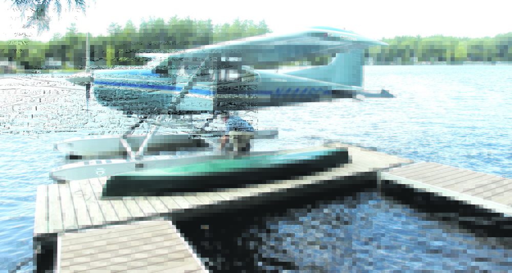 Bill McKay of Oakland secures his float plane to his dock on Messalonskee Lake in this August 2006 file photo after taking a short flight.