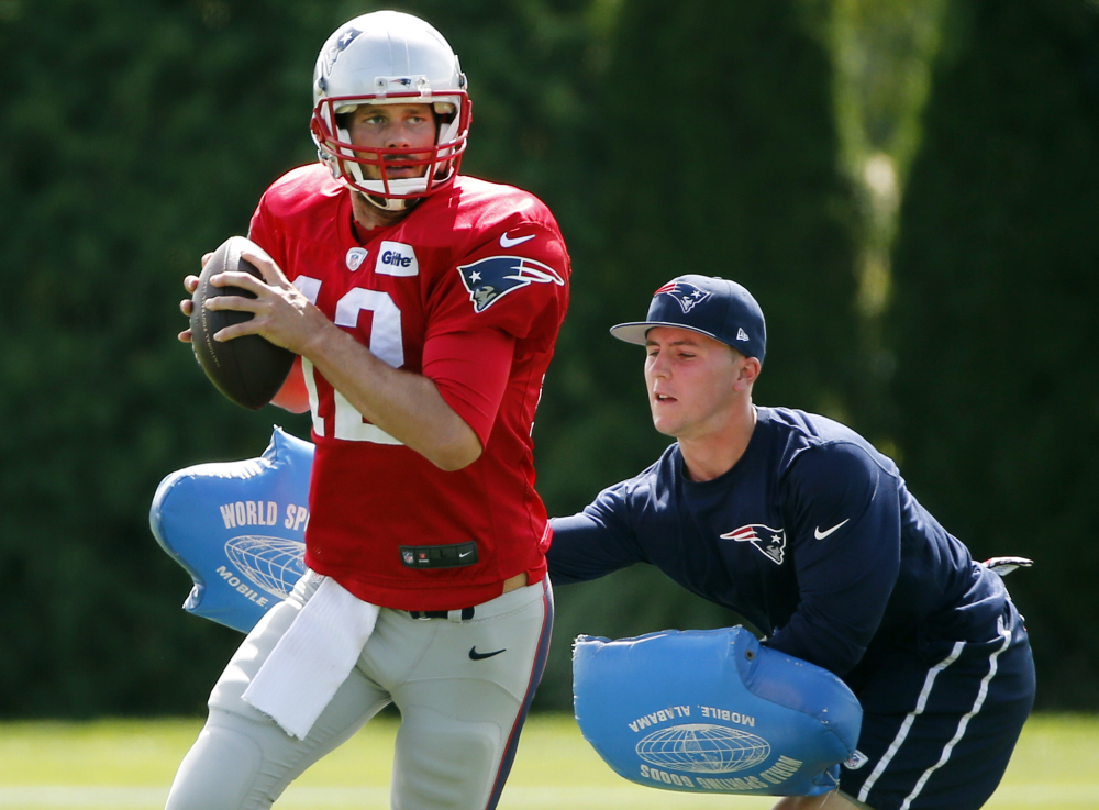 New England Patriots quarterback Tom Brady passes under pressure during a drill at practice Wednesday in Foxborough, Mass. The Patriots are preparing for their opening NFL football game against the Miami Dolphins on Sunday in Miami.