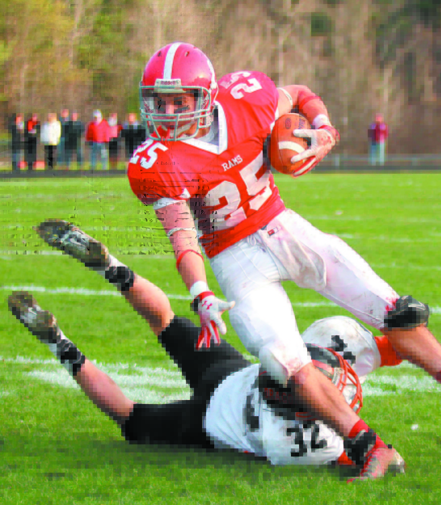 Cony High School’s Tayler Carrier looks up field while trying to get around an arm tackle by Brunswick High School’s Jared Jensen in the first half of a Pine Tree Conference Class A seminfinal game last season. The high school football season kicks off Friday.
