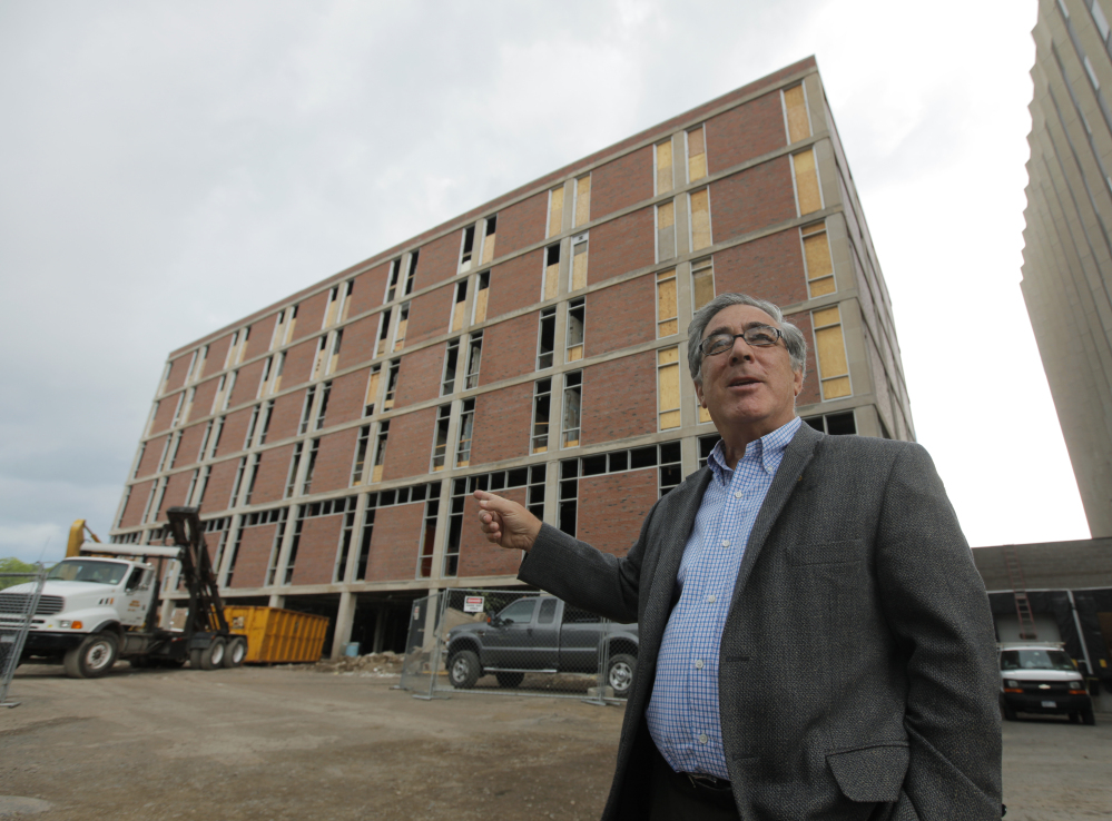 In this June 24, 2010 photo, developer Larry Glazer gestures toward a building to be demolished on Alexander Street in Rochester, N.Y.