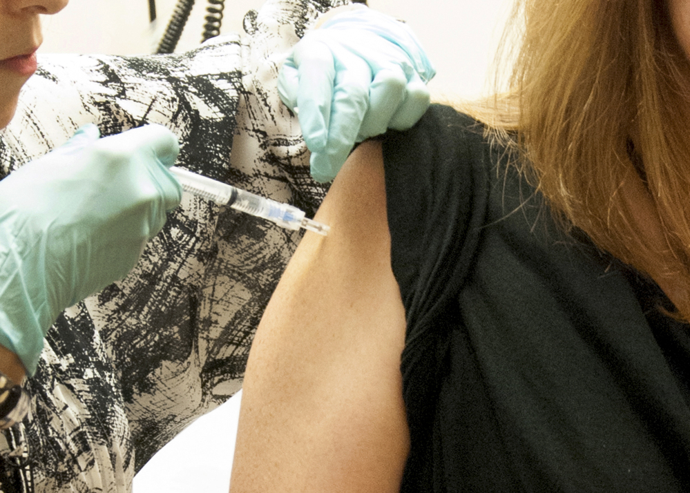 This handout file photo taken Sept. 2, 2014, provided by National Institute of Allergy and Infectious Diseases (NIAID) shows a 39-year-old woman, the first participant enrolled in VRC 207, receiving a dose of the investigational NIAID/GSK Ebola vaccine at the National Institute of Health (NIH) Clinical Center in Bethesda, Md.