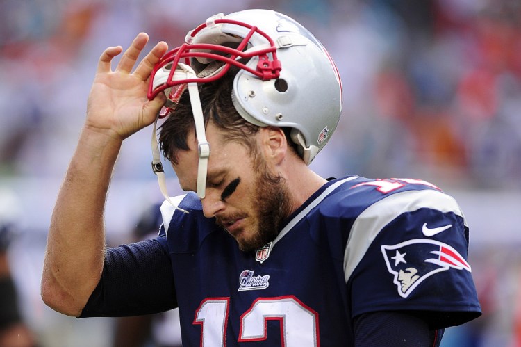 New England Patriots quarterback, Tom Brady removes his helmet after failing to pick up a first down against the Miami Dolphins late in the fourth quarter Sunday at Sun Life Stadium in Miami. Miami beat New England 33-20.