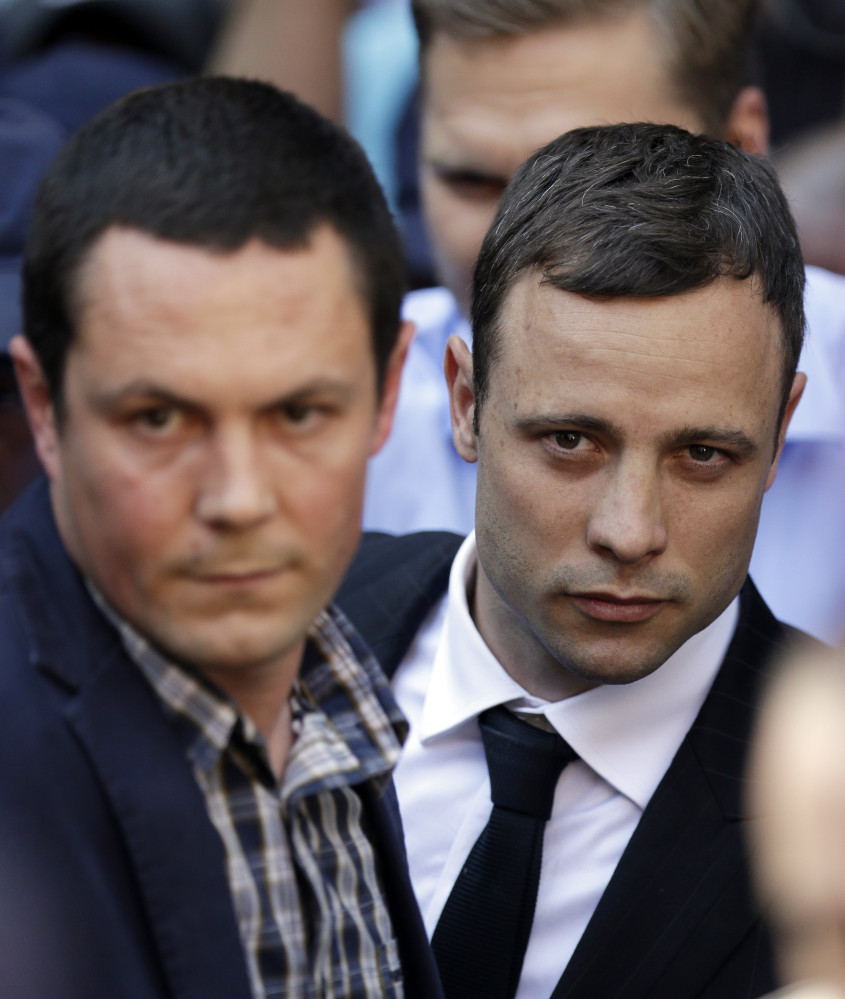 Oscar Pistorius, right, accompanied by a relative, leaves the high court in Pretoria Thursday.