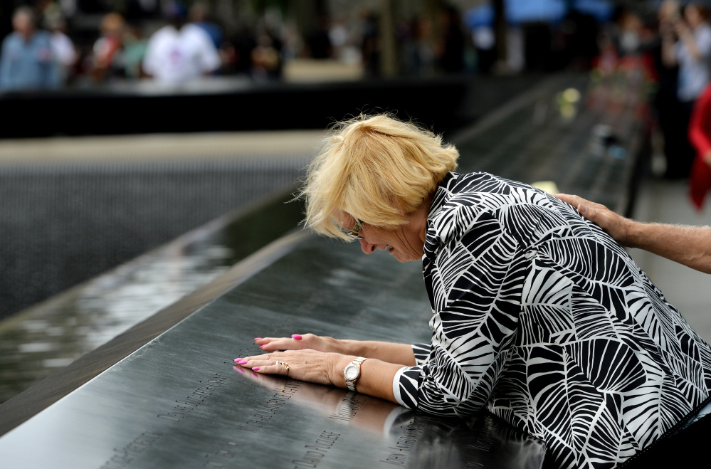 Paola Braut of Belgium cries over a photograph of her son Patrice along the edge of the North Pool during memorial observances on the 13th anniversary of the Sept. 11 terror attacks on the World Trade Center in New York.