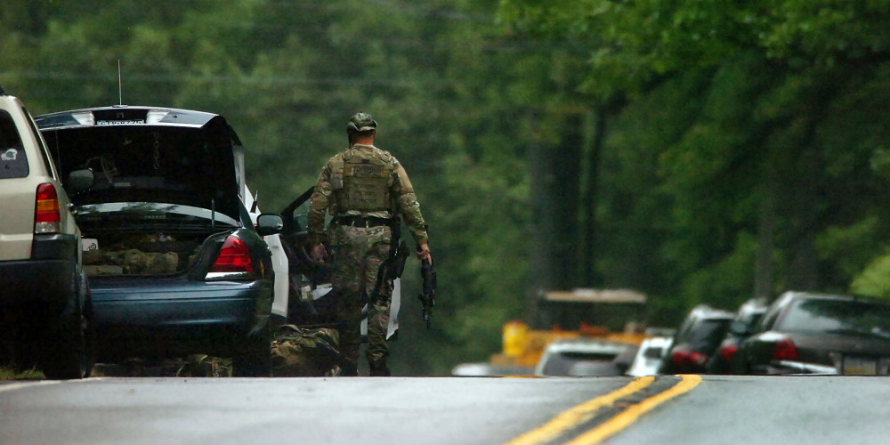 A member of the Pennsylvania State Trooper’s Tactical Response Unit stands near his vehicle on Route 402 on Saturday near the scene where a Pennsylvania State Trooper was killed and another trooper was injured during a shooting late Friday night at the Pennsylvania State Police barracks in Blooming Grove Township, Pa.