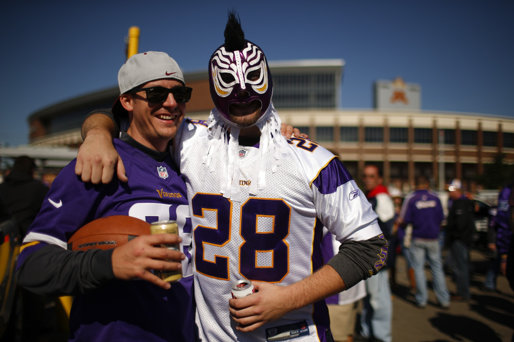 Two fans tailgate outside TCF Bank Stadium wearing Adrian Peterson jerseys before the start of an NFL football game between the Minnesota Vikings and the New England Patriots, Sunday, Sept. 14, 2014, in Minneapolis. Peterson was indicted in Texas on Friday for using a branch to spank one of his sons. He turned himself in early Saturday at a jail in Montgomery County, was processed and released, and deactivated by the Vikings for Sunday's game.  (AP Photo/The Star Tribune, Jeff Wheeler)  MANDATORY CREDIT; ST. PAUL PIONEER PRESS OUT; MAGS OUT; TWIN CITIES LOCAL TELEVISION OUT