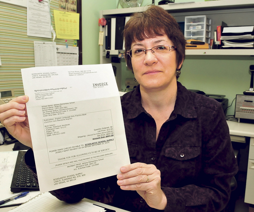 Athens Community School Administrative Assistant Nancy Martin holds the original invoice for books that the school was billed for but did not order.